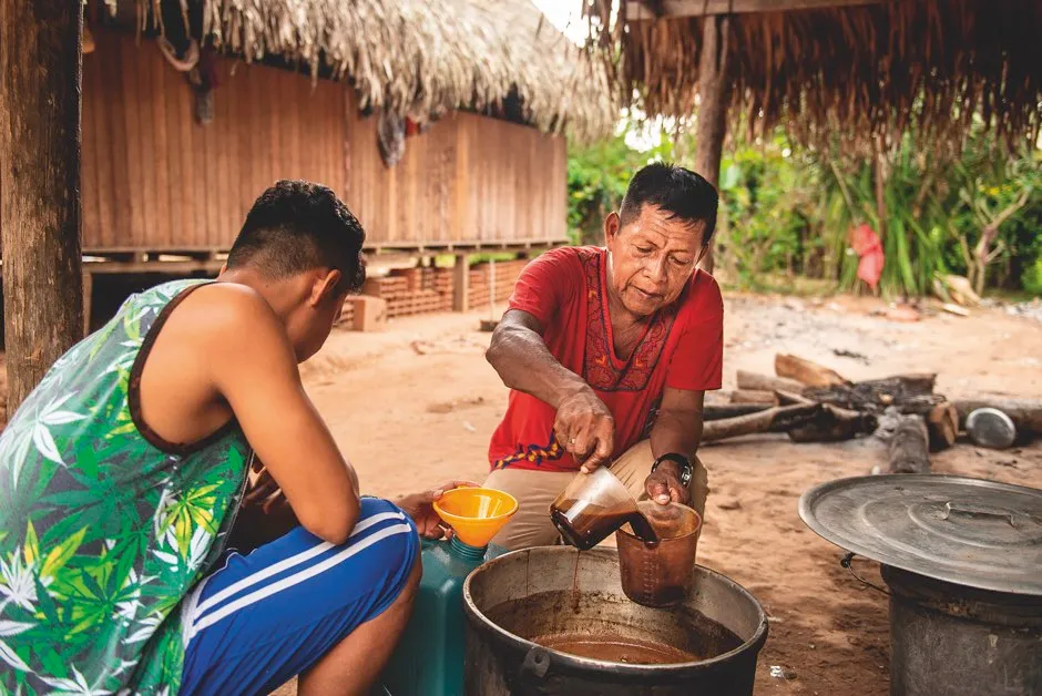A shaman in the Amazon pours ayahuasca brew in readiness for a spiritual ceremony © Alamy