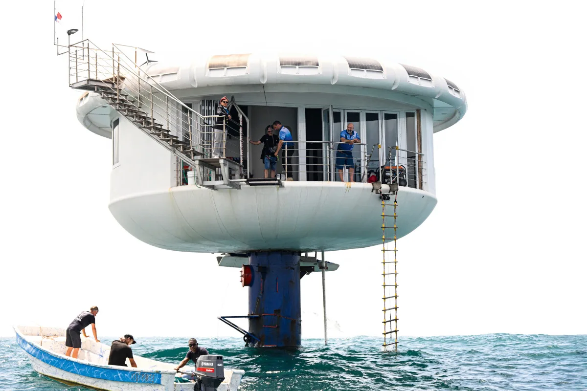 German aerospace engineer Rudiger Koch, 59, (R) stands on the balcony of the seepod after breaking the Guinness world record for living in the ocean at a depth of eleven meters off the coast of Puerto Lindo, Panama, on January 24, 2025.